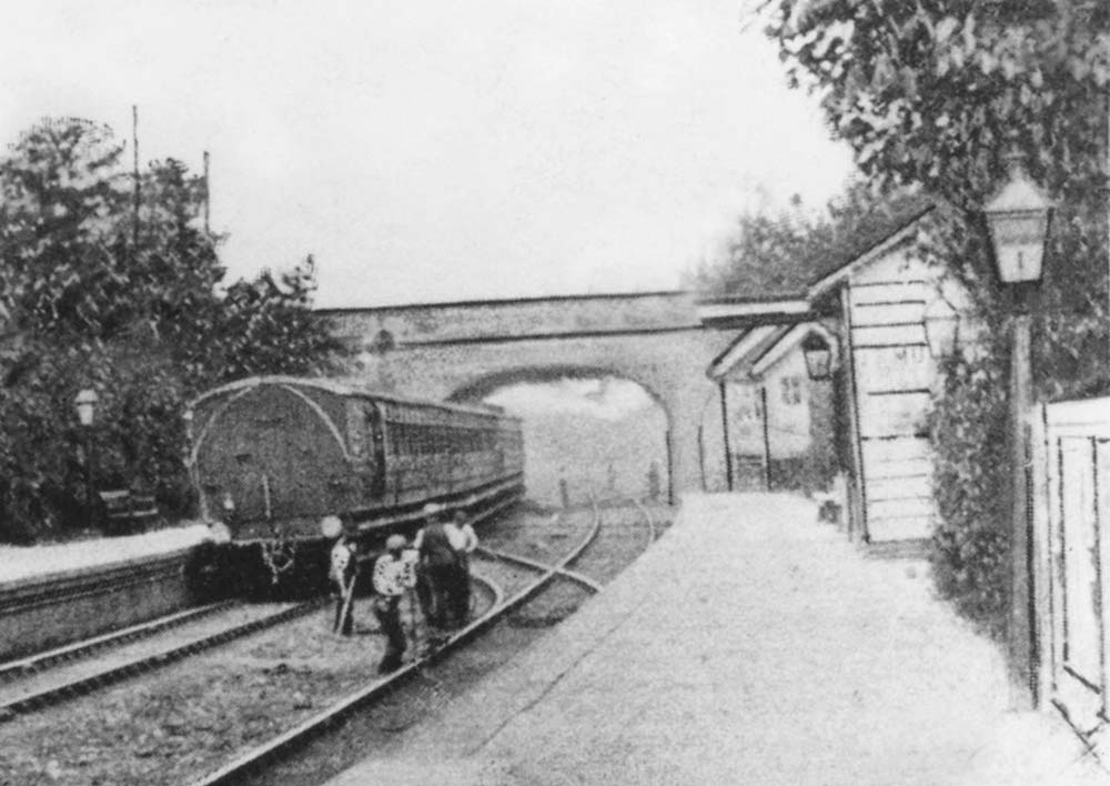 Close up showing the GWR local passenger service leaving the station for Birmingham and a Permanent Way gang working on the track