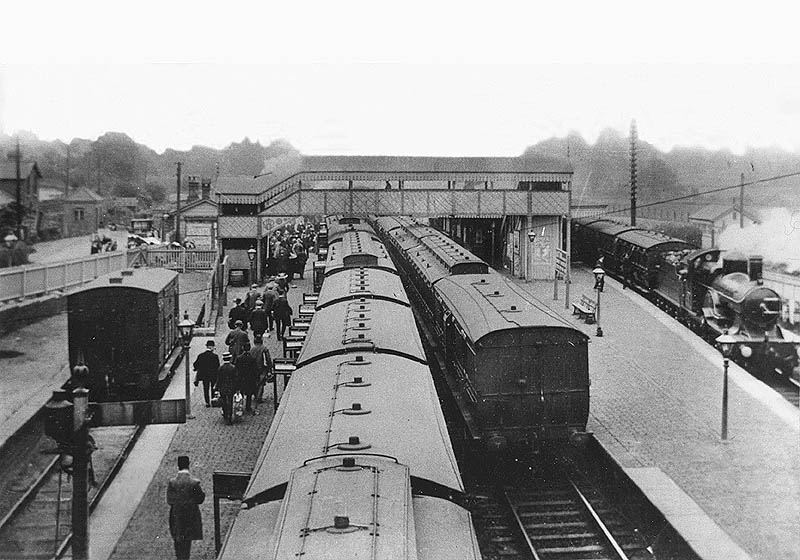 A view of a busy Hatton Station looking east towards Warwick from the road bridge with the mainstation and forecourt on the left
