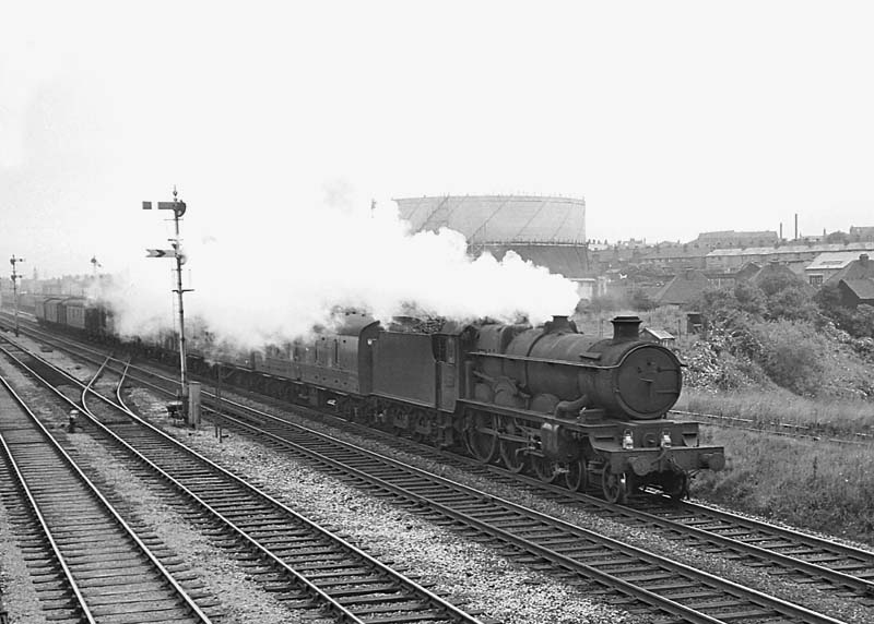 An unidentified ex-GWR 4-6-0 on a Type 4 working is working hard as it passes Queens Head Signal Box on 22nd July 1964