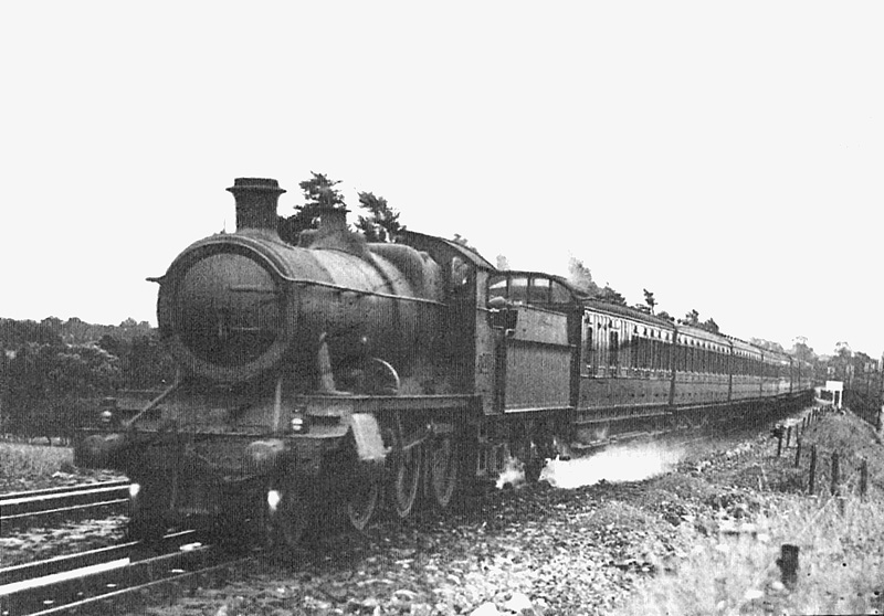 Great Western Railway 2-6-0 43xx class mogul No 6385 picking up water as it heads north with a rake of ex-SECR stock in 1933