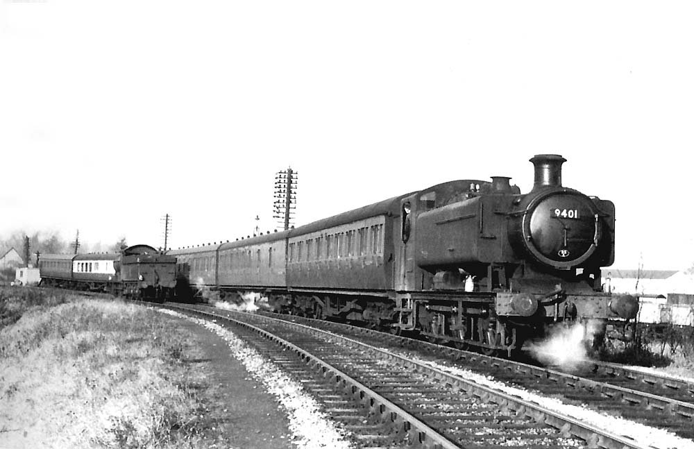 Ex-GWR 0-6-0PT 94xx class No 9401 is seen on a Worcester local passenger working as it approaches the bridge carrying the former SMJ line