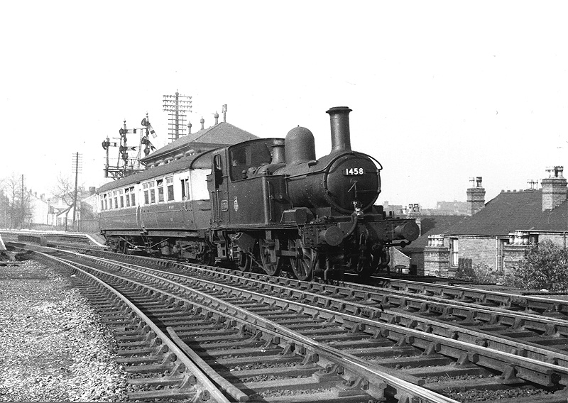 Ex-Great Western 14XX 0-4-2T No 1458 in black British Railways livery coupled with an auto-trailer pulls away from Soho and Winson Green Station