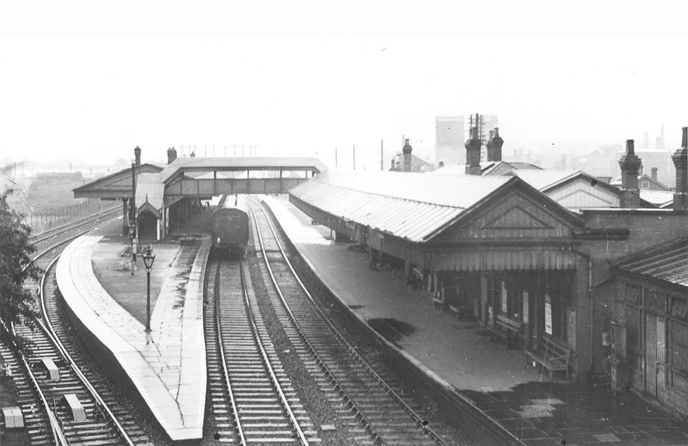 View of Stratford on Avon station from Alcester bridge showing two sets of tracks alongside Platform 3 and an up local passenger service to Birmingham