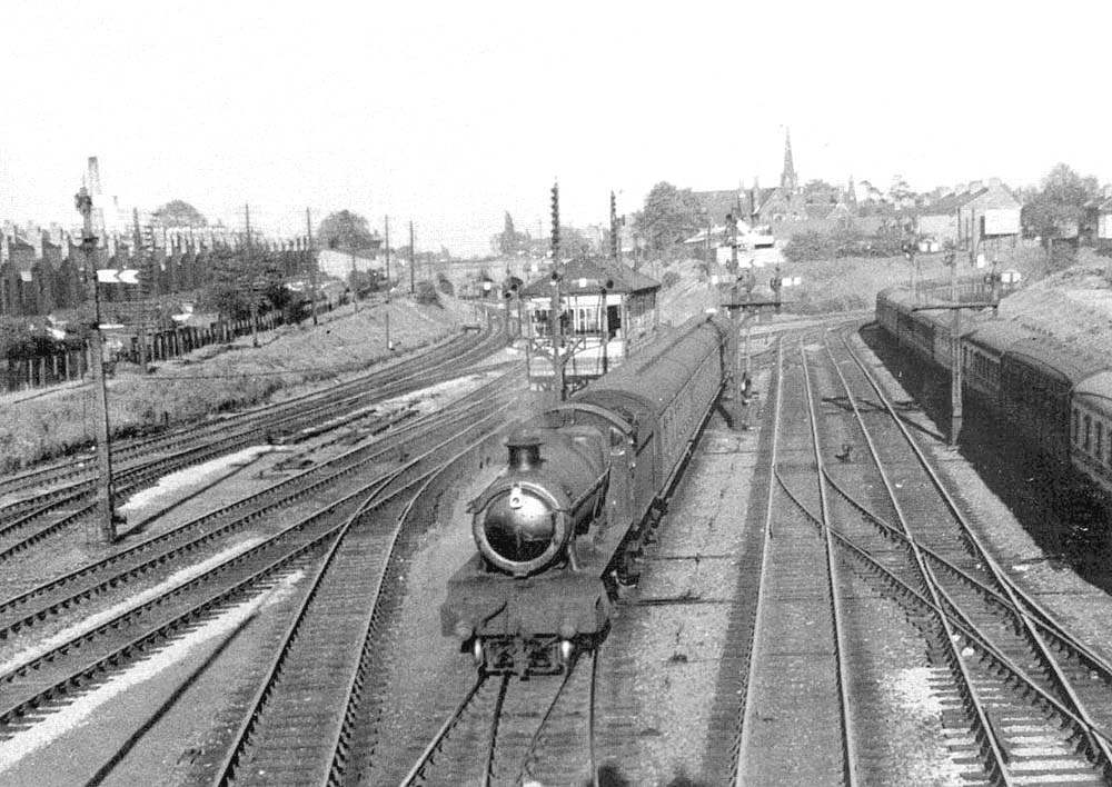 An unidentified ex-GWR 4-6-0 Hall class locomotive is seen at the head of a three-coach local passenger service from Stratford upon Avon in the early 1960s