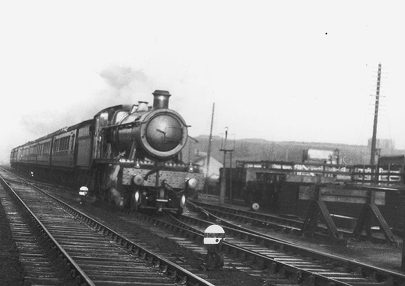 GWR 4-6-0 49xx class No 4935 'Ketley Hall' is seen at the head of an up express train as it passes by the goods yard