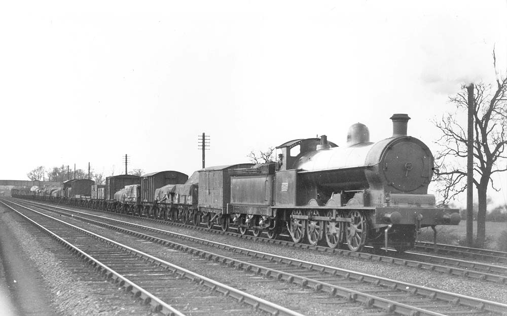 LNWR 0-8-0 No 2562 is seen at the head of a long up mixed goods train travelling on the fast line near Atherstone