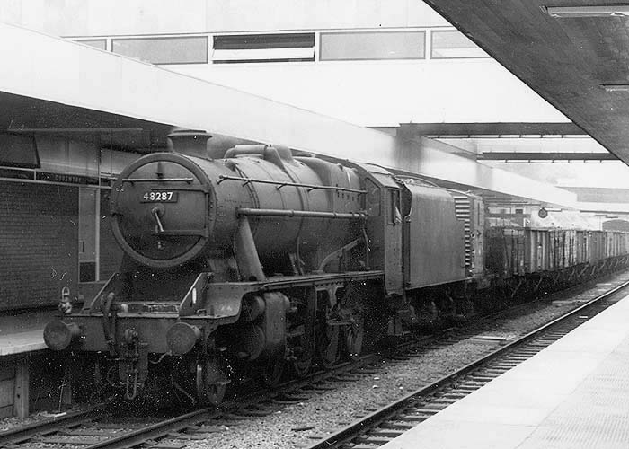 Ex-LMS 2-8-0 8F No 48287 is seen at the head of an up mineral train passing through platform two ready to take the branch for Leamington