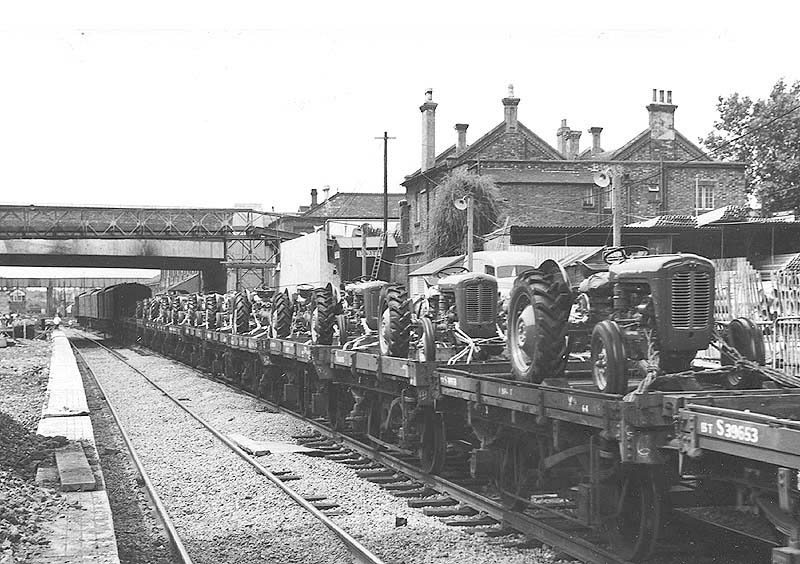 A train of Massey-Ferguson tractors on their way to Southampton docks passes Coventry station during reconstruction
