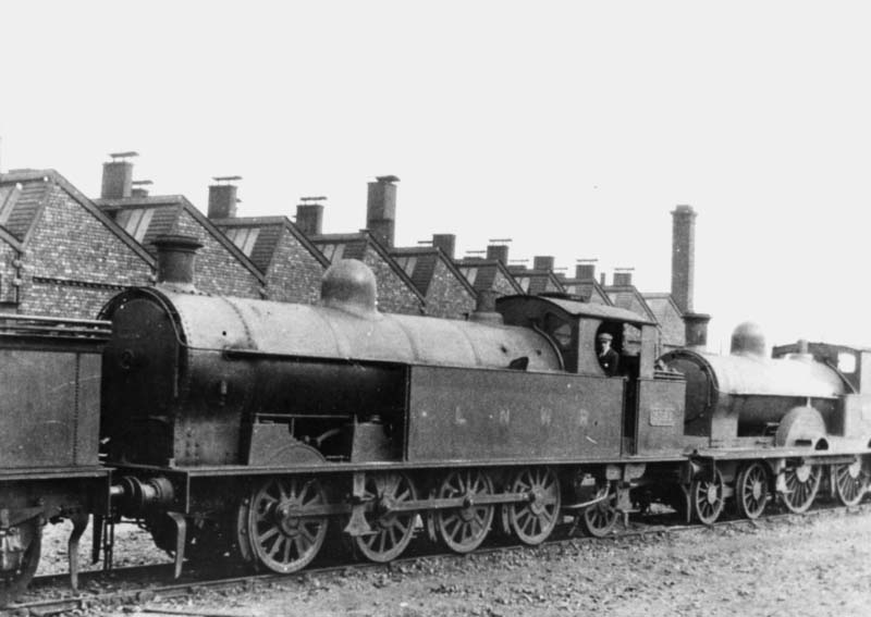 Ex-LNWR 0-8-2T 6F No 2341 is seen standing in line in front of an unidentified ex-LNWR 4-4-0 Precursor class locomotive alongside Nuneaton shed