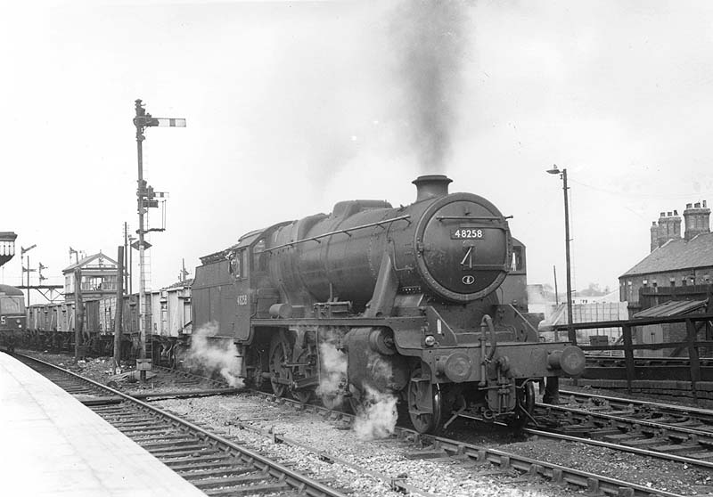 Ex-LMS 2-8-0 8F No 48258 is seen departing the up marshalling yard at the head of a Class J empty mineral train