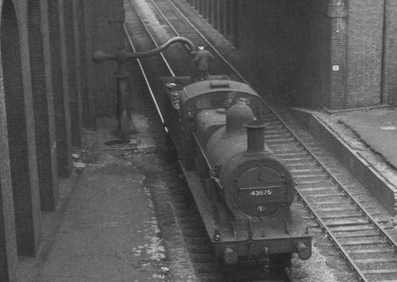 Close up showing the fireman topping up the tender of ex-MR 0-6-0 3F No 43675 before running on to New Street station