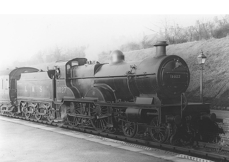 The driver of LMS 4-4-0 "Compound" No 1027 poses for the camera as it passes through the station