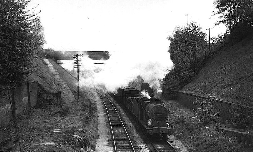 Ex-LMS 0-6-0 4F No 44150 passes the site of the now closed Moseley station as it passes under Woodbridge Road bridge