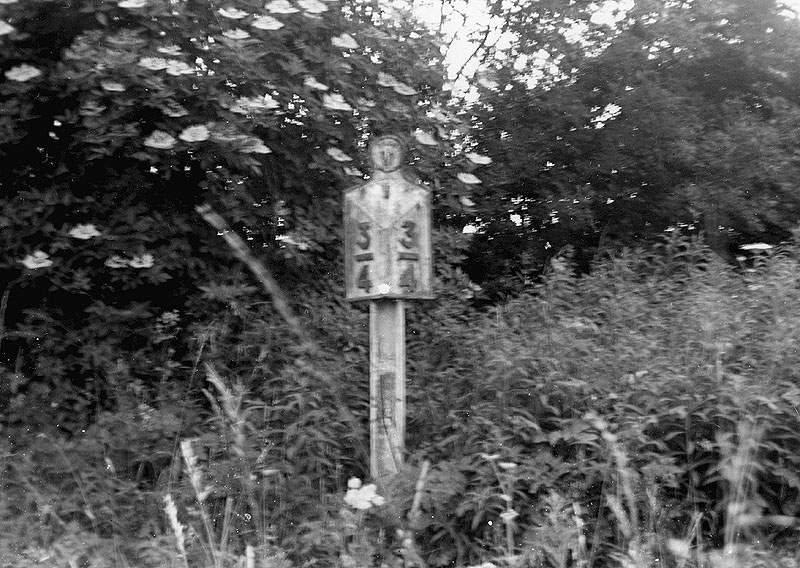View of a mile post sign mounted on top of some early Victorian rail near Coleshill station on 8th July 1951
