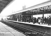 Looking towards Leamington as a local passenger train passes under the footbridge as it arrives at the down main platform