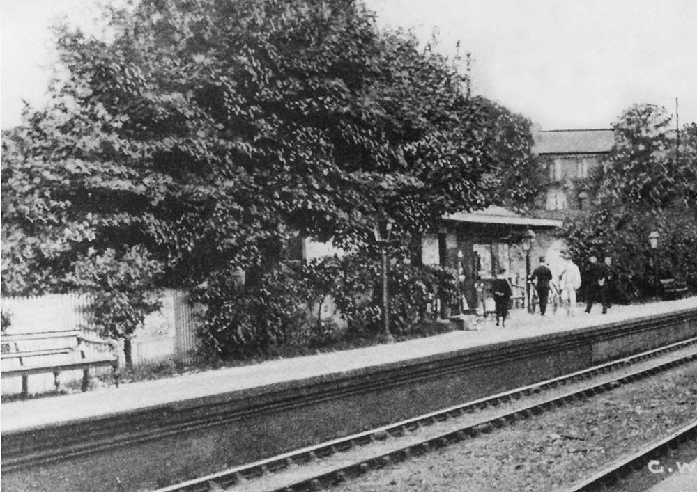  Close up showing Acock Green station's down platform, station staff and passengers after disembarking from train