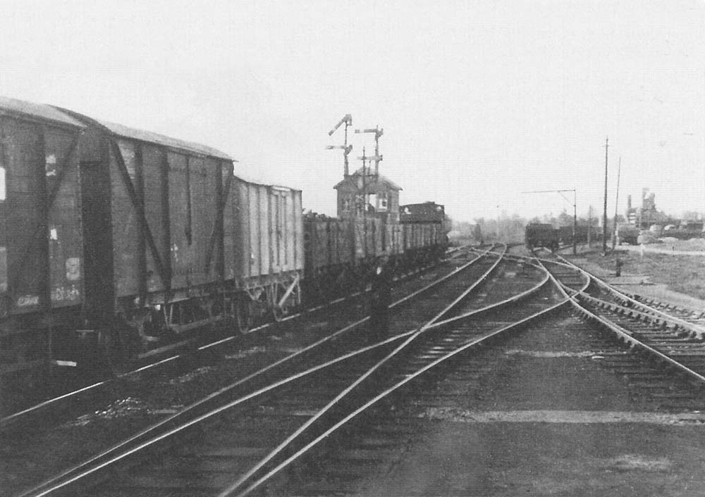 A 1956 view of Bearley East Junction Signal Box as an early morning freight to Honeybourne passes the goods yard