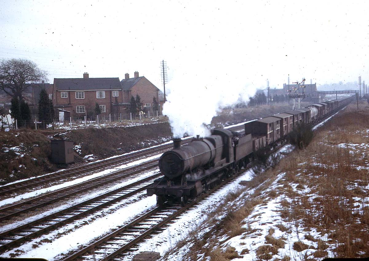 An unidentified ex Great Western Railway 2884 class 2-8-0 locomotive with a northbound class E express freight passes Bentley Heath Crossing on the down relief line