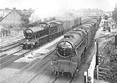 Ex-GWR 2-8-0 28xx Class No 2875 is seen on the left on a down fitted freight as it passes British Railways built 4-6-0 Class 5 No 44663 which is on a part fitted service