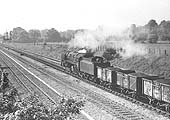 An unidentified British Railways 2-10-0 Standard Class 9F is approaching Bentley Heath crossing with an up coal train