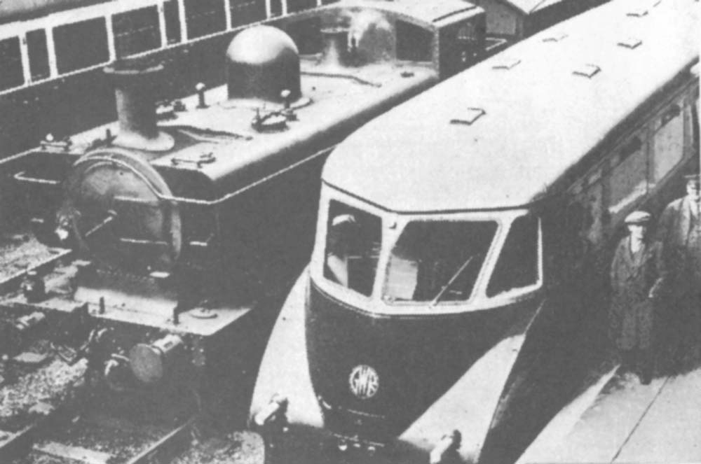 An unidentified GWR 0-6-0PT locomotive is seen passing an unknown GWR Railcar whilst at the head of an up freight working from Bordersley