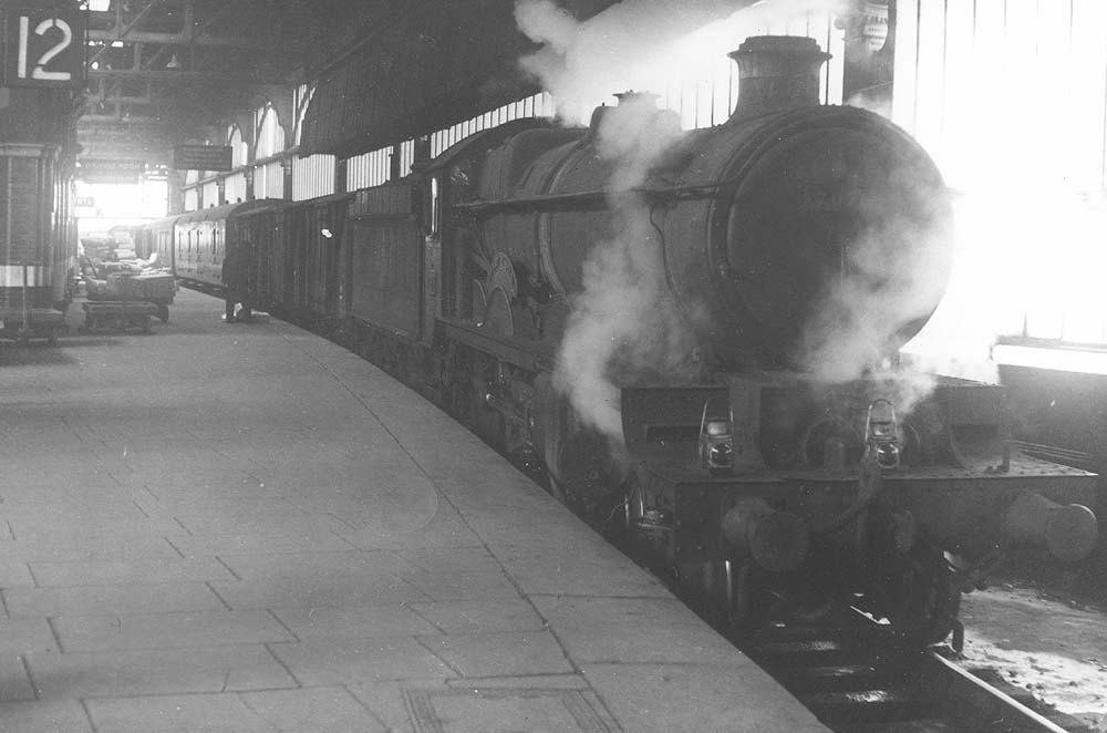 Ex-GWR 4-6-0 Castle class No 7026 'Tenby Castle' is seen with steam leaking from its cylinders whilst standing at Platform 12 at the head of an up Class C express parcels train