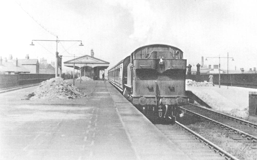 An unidentified ex-GWR 2-6-2T 'Prairie' locomotive is seen running bunker first on the up relief road with a Class B local passenger service