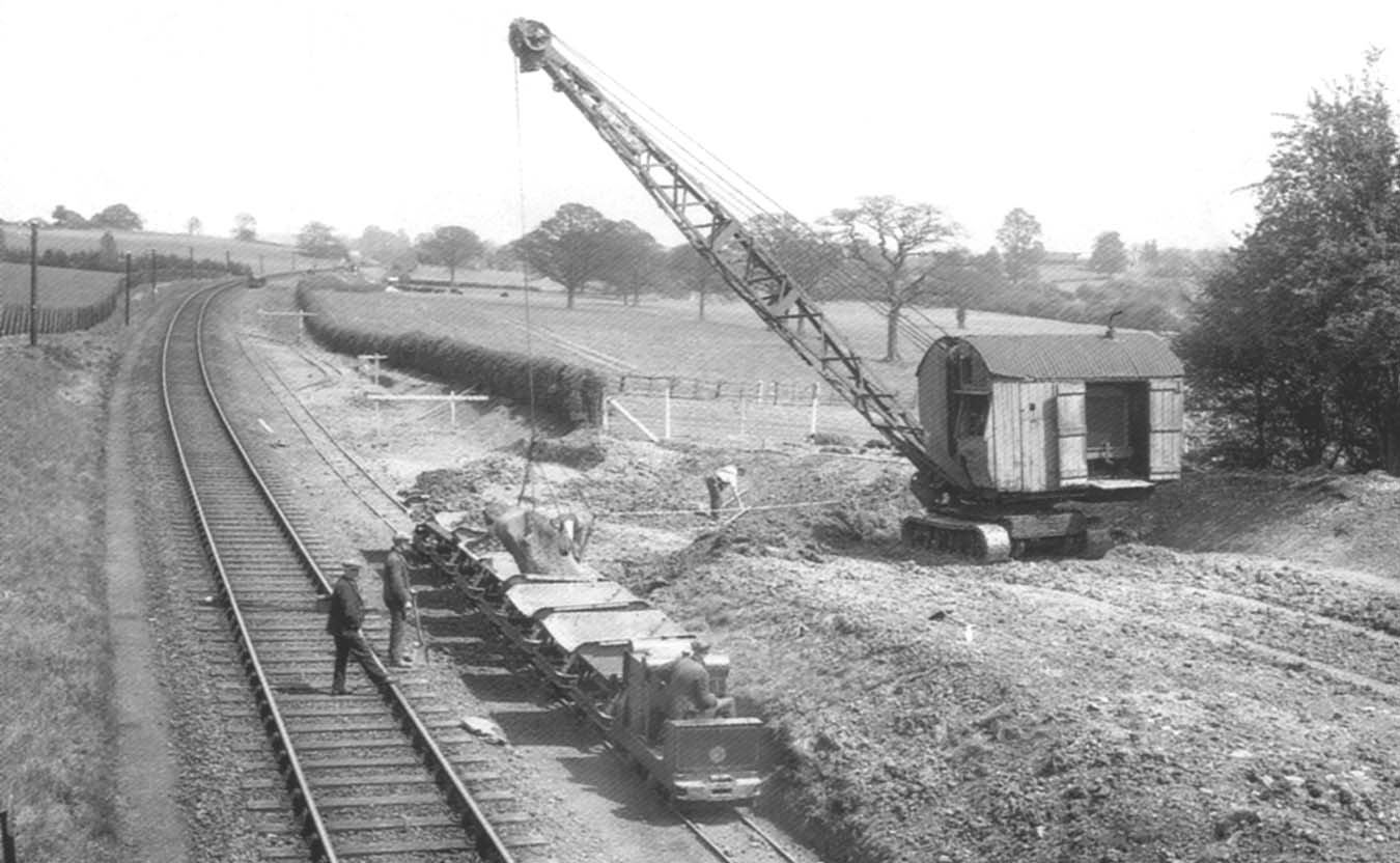 View of the widening works with a contractors narrow gauge tramway being loaded by a crawler crane and bucket