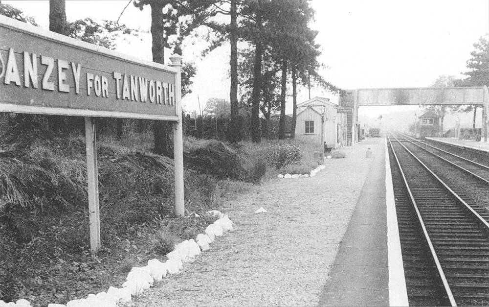 Looking towards Birmingham along the up platform with the replacement concrete passenger footbridge in the middle distance and signal box beyond