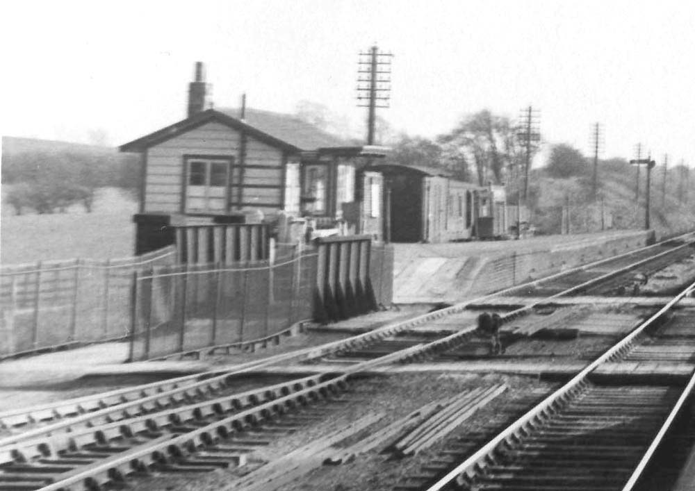 Close up  showing the booking office, timber framed store and grounded coach body on the up platform