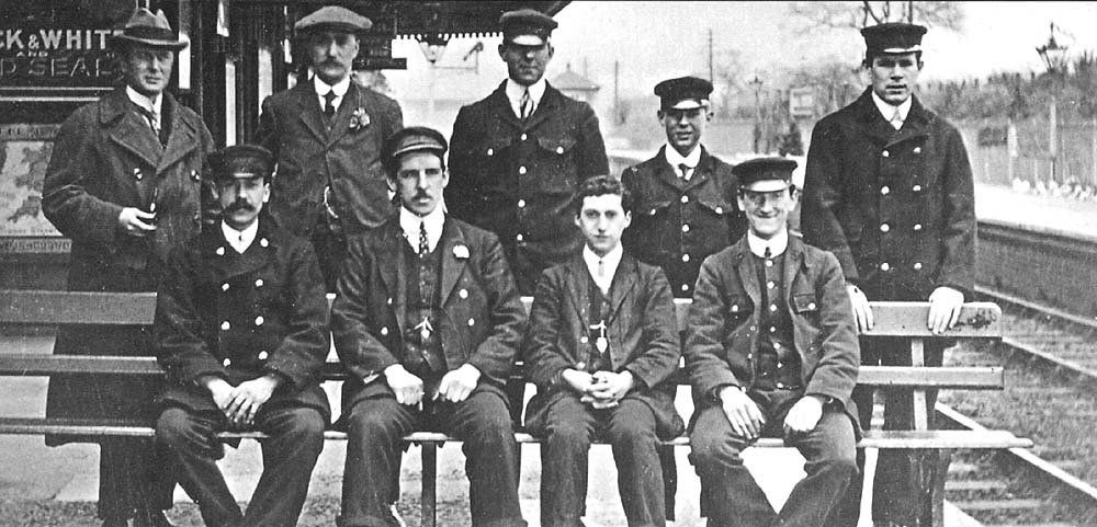 View of Hall Green's station staff, including porters and signalmen, seated on the Birmingham platform whilst posing for the camera