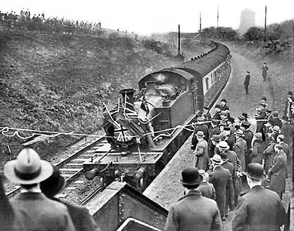 The GWR 2-6-2T locomotive arrives at the new Halt breaking a tape consisting of the two teams club colours