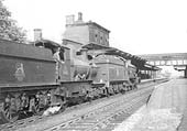 A pair of unidentified engines, a 4-6-0 Castle and an outside framed 4-4-0 are seen passing through the station on an up express service