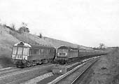 A single car DMU to Leamington Spa is seen on passing the Paddington to Chester service headed by D1756 on 19th February 1966