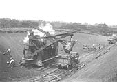 A mechanical steam shovel is being used with a gang of navvies to trim the cutting near Crockets Farm bridge