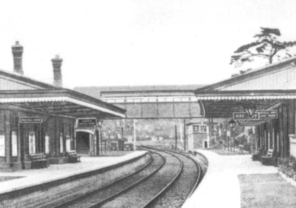 Close up showing the island platform on the left and the down platform on the right being connected by a steel covered passenger footbridge