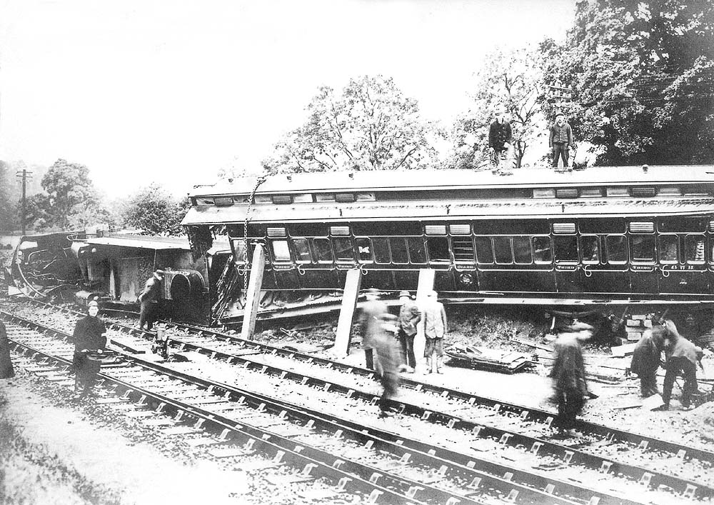 View of Tyseley shed's breakdown gang inspecting the damage caused to the first coach immediately behind the tender