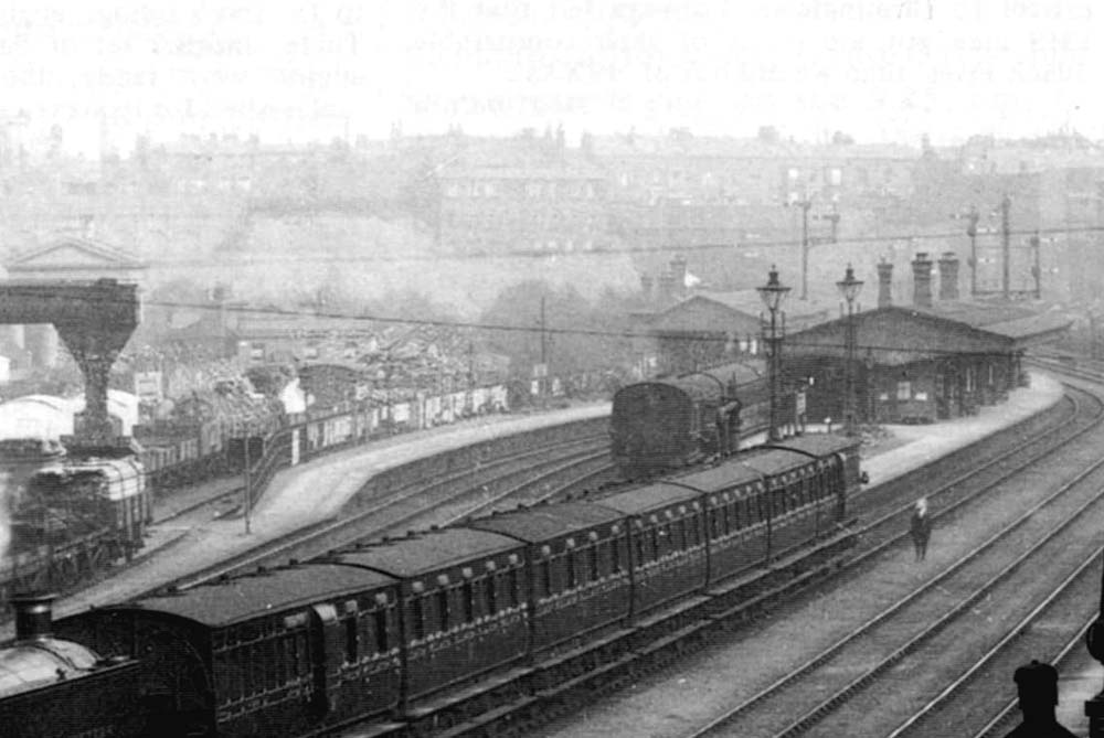 Close up showing the station as a local service stands at platform 2 whilst a down service leaves platform 3