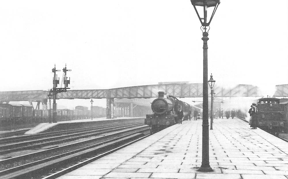An unidentified GWR 4-6-0 Saint Class locomotive stands at the down platform circa 1920