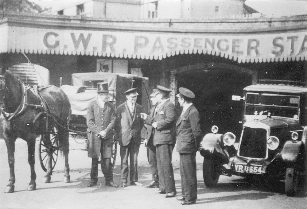 Horse drawn cab and motor taxi stand side by side outside the subway prior to the rebuilding