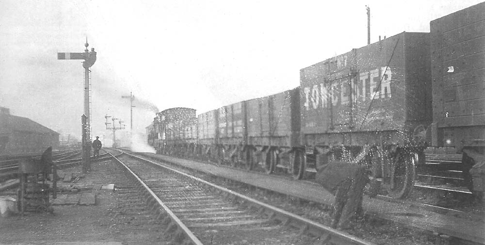 A GWR 'Standard Goods' 0-6-0 stands at the Birmingham end of the station with a train comprising empty coal wagons