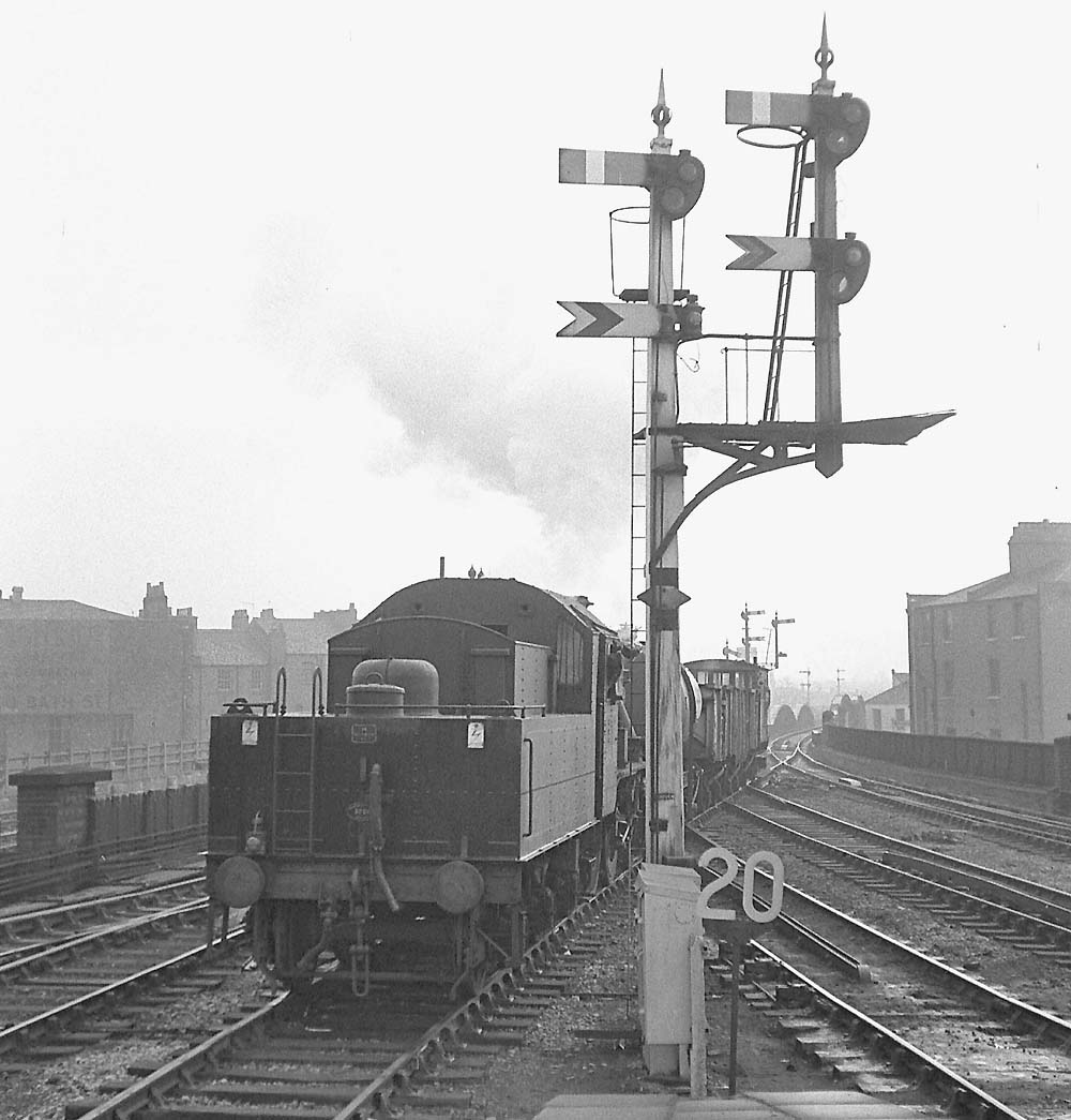 British Railways built Ivatt 2MT 2-6-0 No 46420, running tender first on a short goods train, crosses on to the down loop line