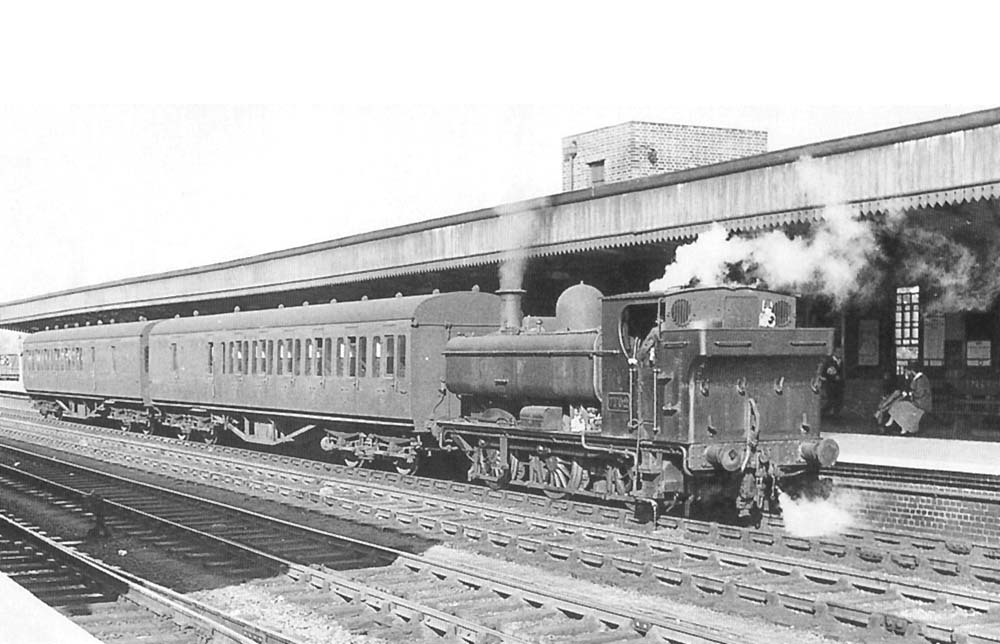 Ex-GWR 57xx Class 0-6-0PT No 7702 stands at Leamington's up platform with a train from Stratford upon Avon