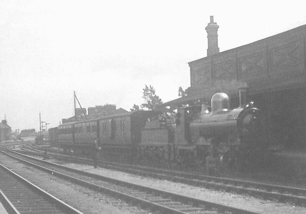 GWR 2-4-0 'Stella'  stands at the head of a train consisting of a Van, Composite and Third in the down platform