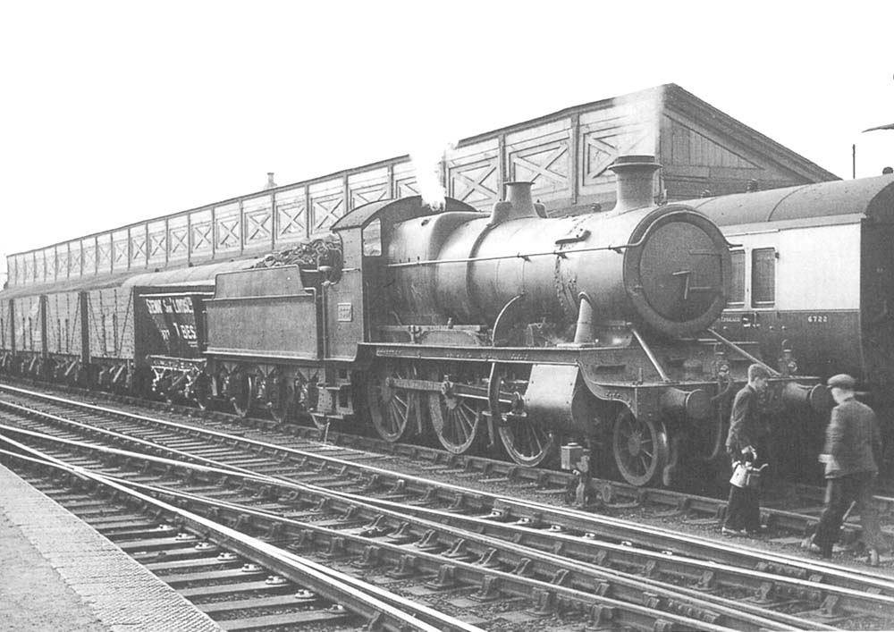 GWR 2-6-0 Mogul No 4337 is seen paused on the up through road heading a train of Stewart & Lloyd hoppers