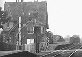 Close up showing Milcote's home starter signal on a bracket signal post with the two road goods yard beyond