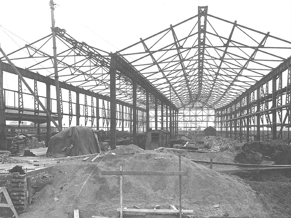 Erection of the steel framework and braced roof trusses of the four hundred foot long top level shed nears completion