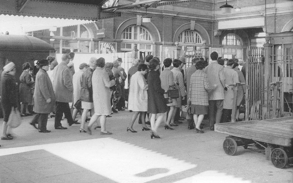 A group of morning commuters are seen going through Moor Street's ticket barrier on 30th April 1969