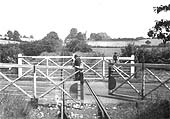 View of the guard of an up freight train closing the gates at Fosse Road Level Crossing, near Shipston-on-Stour