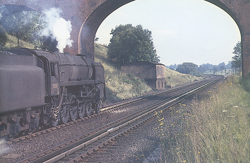 British Railways 2-10-0 Standard Class 9F No 92007 is seen on a Wolverhampton to Swindon 'Enparts' train carrying parts for works and shed repairs